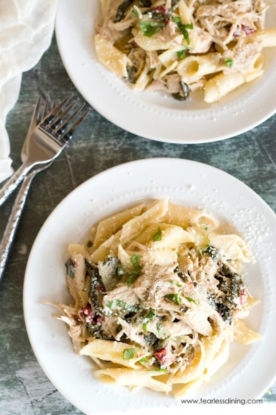 Two plates full of the gluten free Tuscan chicken pasta.